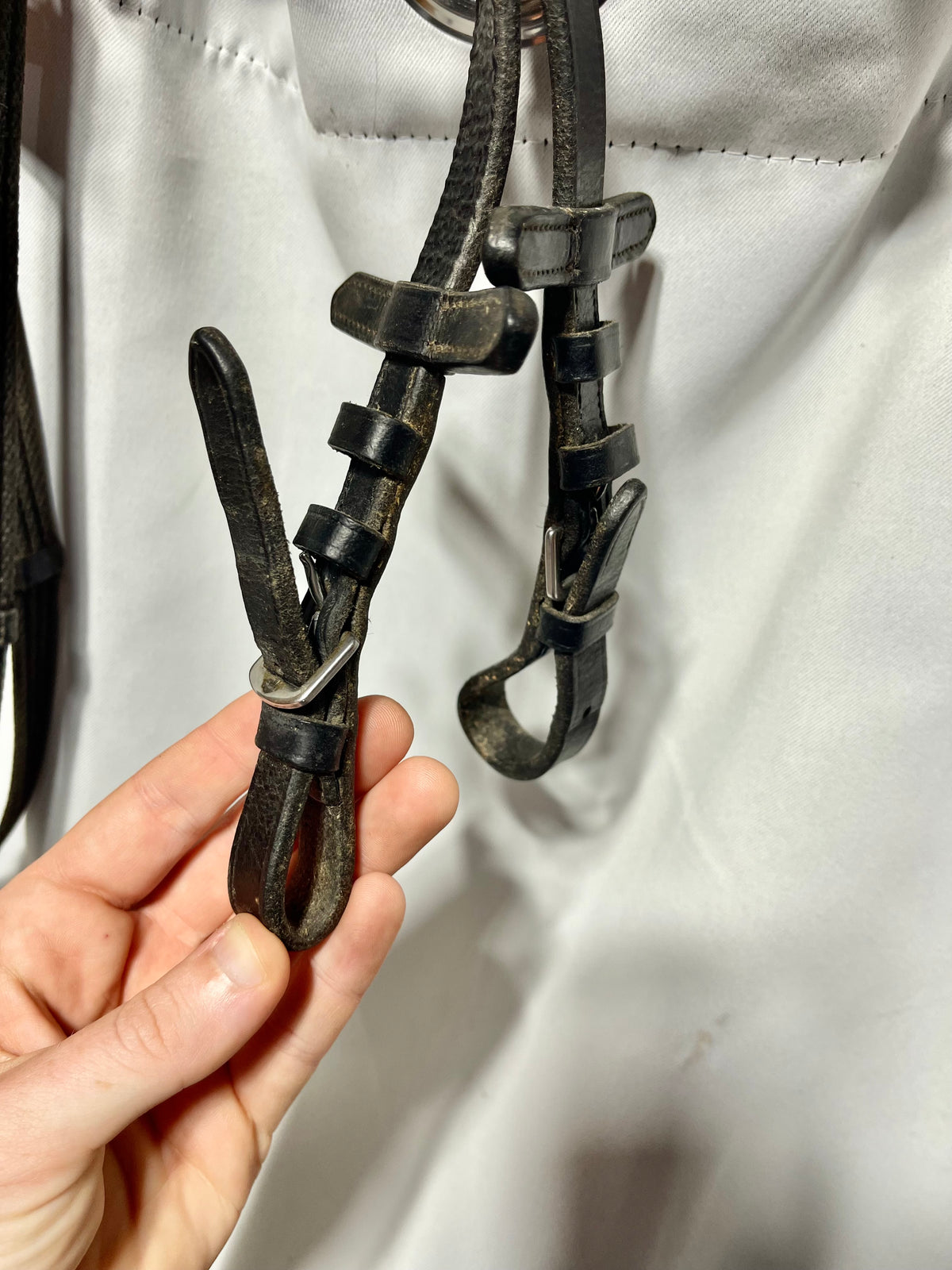 56" x 5/8" English Black Cotton webbed reins with leather stoppers and leather ends. Buckle ends
